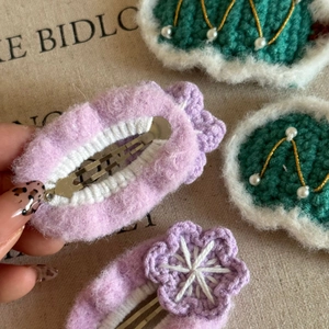 Detailed close-up of handmade crochet flower hair clips with soft wool and pearl accents