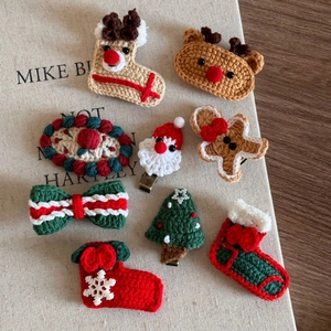 Detailed view of handmade knitted Christmas hair clips featuring reindeer and Santa designs