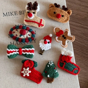 Detail view of 9-piece handmade crochet Christmas hair clips featuring Santa and reindeer
