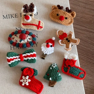Detailed view of handmade crochet Christmas hair clips featuring Santa and reindeer designs