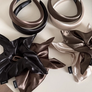 Close-up of silk satin scrunchies and headbands with handmade labels in earth tones