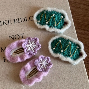 Close-up of knit Christmas hair clips with pearls and fabric flowers on canvas