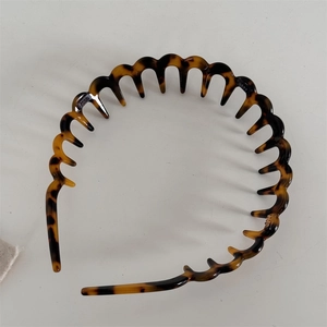 Detail view of wavy tooth comb headband with classic tortoiseshell pattern design