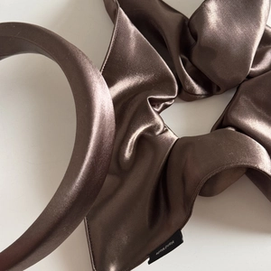 Detail of luxury silk satin scrunchie and padded headband in dark bronze with handmade label