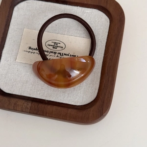 Close-up of leopard print acetic acid plate hair tie with high elastic band on wood tray