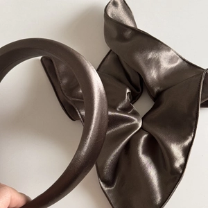 Close-up of dark brown satin scrunchie and padded headband set with silk sheen