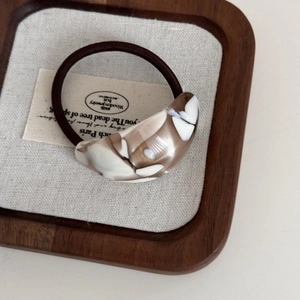 Detail of high-elasticity hair tie with marble-patterned acetate crescent ornament