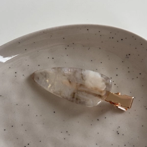Detailed macro of marble texture acetate hair clip with rose gold metal fastener