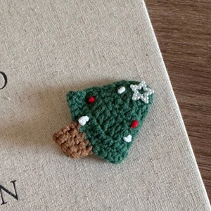 Macro view of a handcrafted green crochet Christmas tree with small red decorations