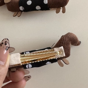 Detail of brown corduroy dachshund hair clip with polka dot fabric and golden metal duckbill clip