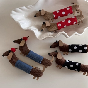 Close-up of cute dachshund dog hair clips in red, blue, and black polka dot fabric