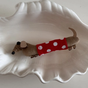 Detailed view of a handmade dachshund fabric hair clip with wooden ears in a white shell tray
