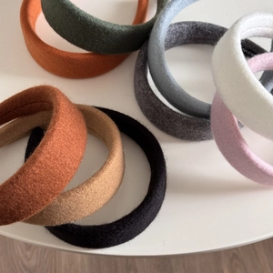 Macro detail of assorted colorful padded fabric headbands featuring a handmade label