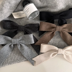 Flat lay of five large ribbed knit bow hair clips in neutral autumn and winter tones