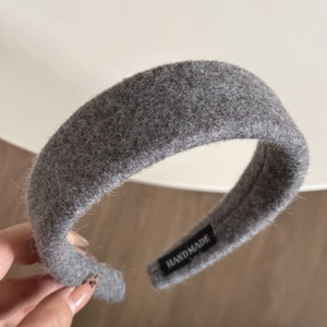Detailed macro view of handmade grey wool headband with stitched brand label