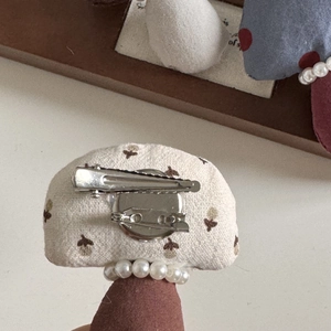 Detalle posterior de horquilla con clip de pico de pato, pasador de broche y perlas