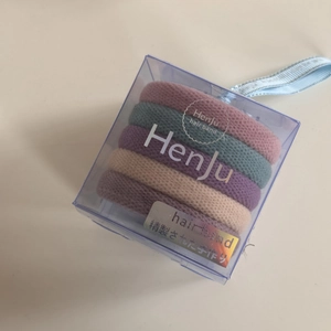 Detail of 5 high-elasticity seamless hair ties in Morandi tones inside a square gift box