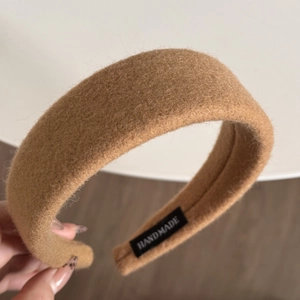 Detail of camel plush wide headband with a handmade label showing soft autumn texture