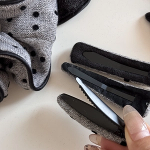 Détails de la barrette en tissu gris à pois avec vue sur le clip crocodile intérieur en métal