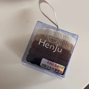 Detailed view of four seamless elastic hair ties in neutral tones within a premium gift box