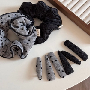 Détail des chouchous et barrettes assortis à pois gris et noirs de style minimaliste