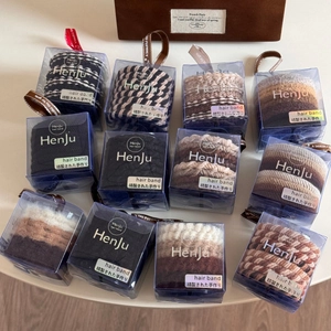 Detail view of elastic hair ties in neutral tones packed in square gift boxes