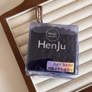 Detail of a high-elastic black hair band in a premium transparent HenJu branded gift box