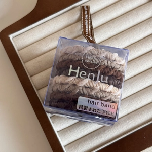 Detail of high-elasticity earth-toned hair bands in a premium branded gift box