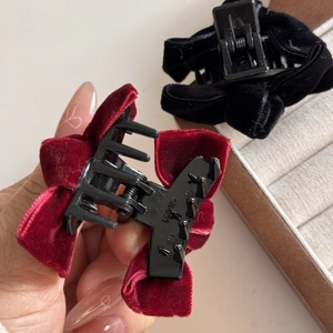 Close-up of velvet bow hair claws in burgundy and black with secure grip teeth