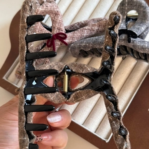 Close-up showing the opening mechanism and tweed fabric of this elegant hair claw clip