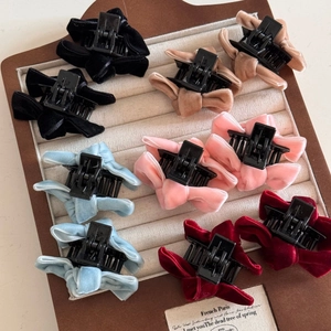Macro detail of velvet bow hair clips set in five colors on jewelry display tray