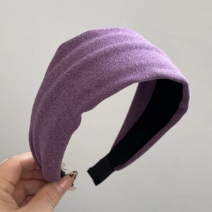 Close-up of purple wide padded headband featuring pleated texture and velvet-like fabric