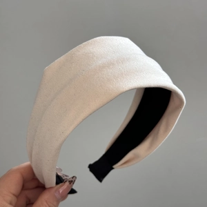 Detail view showing beige fabric texture and black non-slip lining of the wide headband