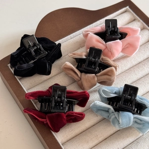 Detailed view of 5 velvet bow hair claws in black pink beige red and blue colors