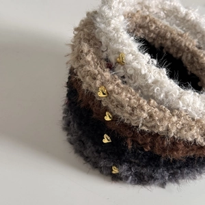 Gros plan de bandeaux en peluche en quatre couleurs avec breloques cœur en métal doré