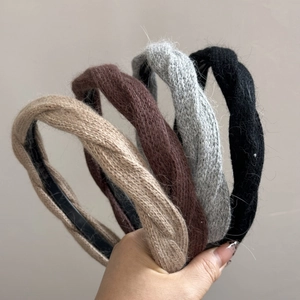 Dettaglio di fasce per capelli in maglia intrecciata nei colori beige, caffè, grigio e nero