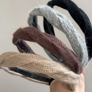 Dettaglio di quattro fasce per capelli in maglia soffice in beige, marrone, grigio e nero