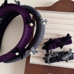 Detail of purple velvet sponge headband with pearls and bow hair clips on display