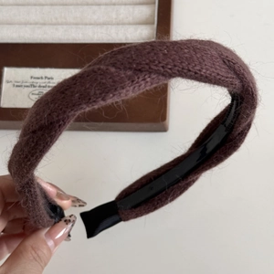 Dettaglio del cerchietto in maglia marrone effetto pelliccia con struttura interna in plastica