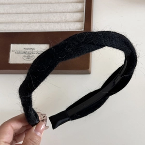 Dettaglio del cerchietto in peluche nero che mostra la morbida trama e il supporto interno