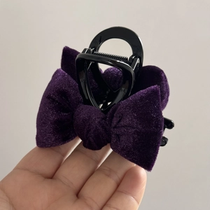 Close-up of deep purple velvet bow hair claw clip with sturdy black plastic grip