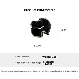 Detail view of black fabric scrunchie with white trim including 15x15cm size specs