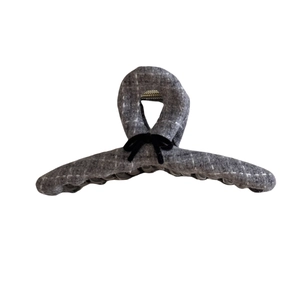 Checkered tweed hair claw clip with black velvet bow accent on white background