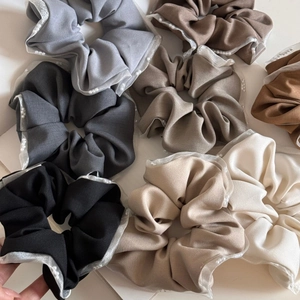Detail shot of mesh scrunchies featuring pearl trim in various earthy color options