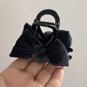 Detail showing plush black velvet bow hair clip with soft texture and elegant design