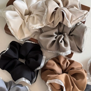 Detail of white mesh scrunchies with faux pearl trim in various neutral earthy colors