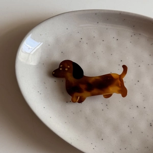 Close-up of dachshund hair clip in brown tortoise shell pattern with gold details