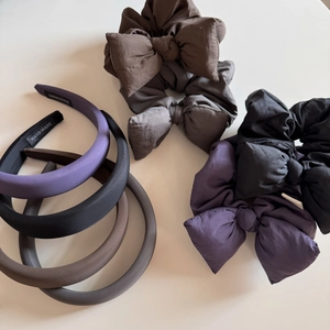 Detailed close-up of handmade purple and neutral fabric scrunchies with woven labels
