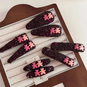 Close-up of cute purple tweed fabric hair clips with small resin bear decorations