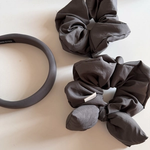 Close-up of handmade dark grey fabric headband and puffy bow scrunchies set